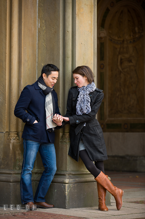 Engaged couple at Bethesda Terrace, Central Park, looking at the diamond engagement ring. Pre-wedding engagement photo session at New York City, NY, by wedding photographers of Leo Dj Photography. http://leodjphoto.com