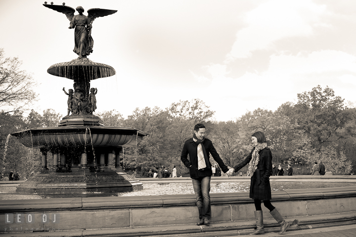 Engaged couple walking by the fountain at Bethesda Terrace, Central Park. Pre-wedding engagement photo session at New York City, NY, by wedding photographers of Leo Dj Photography. http://leodjphoto.com