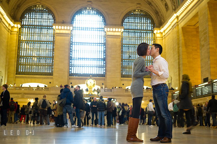 Engaged guy and girl kissing inside the Grand Central Station. Pre-wedding engagement photo session at New York City, NY, by wedding photographers of Leo Dj Photography. http://leodjphoto.com