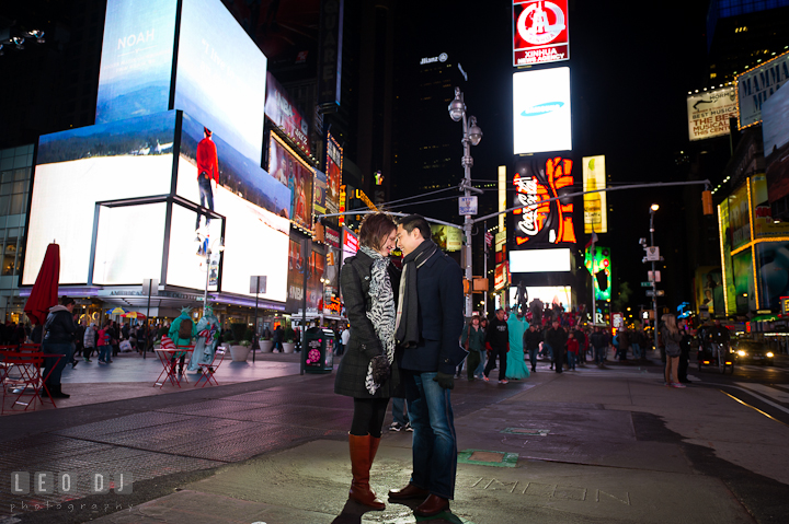 Engaged guy and girl cuddling at the Times Square. Pre-wedding engagement photo session at New York City, NY, by wedding photographers of Leo Dj Photography. http://leodjphoto.com