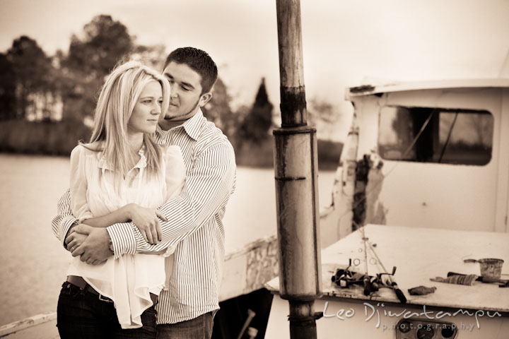 Engaged girl is hugged by her fiancé on a crabbing boat. Stevensville, Kent Island, Maryland, Pre-Wedding Engagement Photographer, Leo Dj Photography