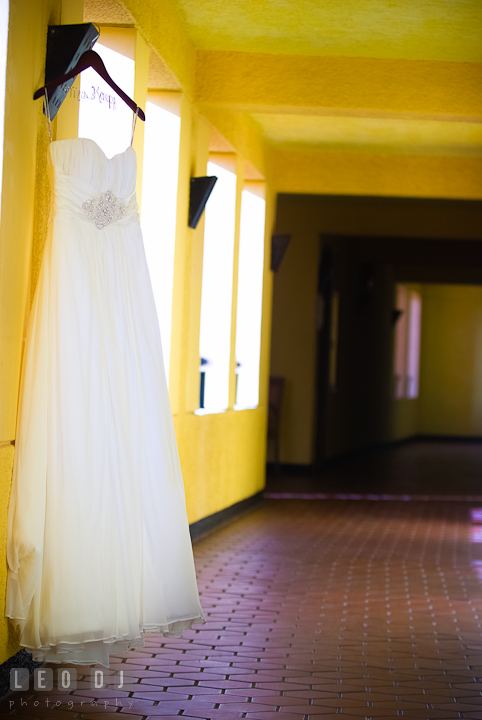 Bride's wedding dress hung at hotel yellow hallway. Cruise ship destination wedding ceremony photos, Hotel Melia Cozumel Mexico by photographers of Leo Dj Photography.
