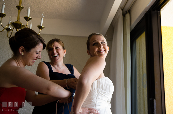 Matron of Honor and mother helping brid putting on wedding dress. Cruise ship destination wedding ceremony photos, Hotel Melia Cozumel Mexico by photographers of Leo Dj Photography.