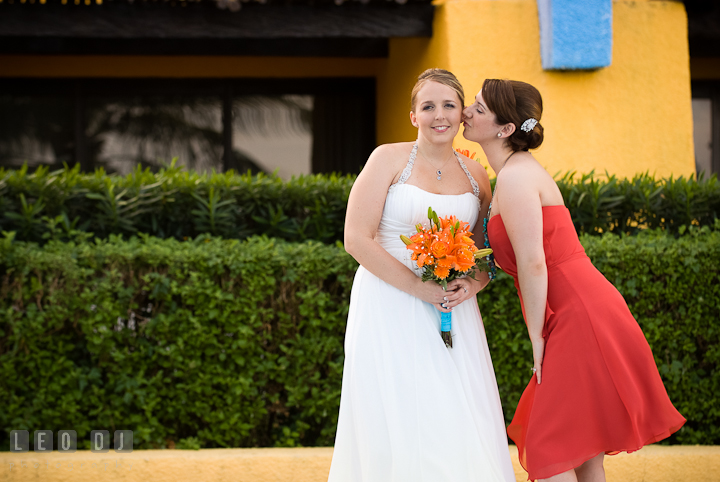 Matron of Honor trying to kiss Bride's cheek. Cruise ship destination wedding ceremony photos, Hotel Melia Cozumel Mexico by photographers of Leo Dj Photography.