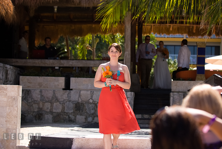 Matron of Honor walking down the isle. Cruise ship destination wedding ceremony photos, Hotel Melia Cozumel Mexico by photographers of Leo Dj Photography.
