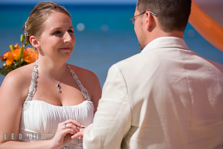 Bride putting on wedding band on Groom's finger. Cruise ship destination wedding ceremony photos, Hotel Melia Cozumel Mexico by photographers of Leo Dj Photography.