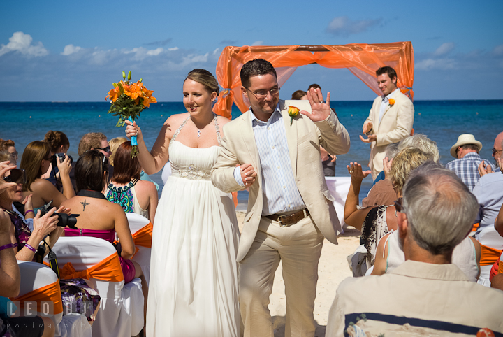 Bride and Groom waved to guests as the walked out from the ceremony site. Cruise ship destination wedding ceremony photos, Hotel Melia Cozumel Mexico by photographers of Leo Dj Photography.
