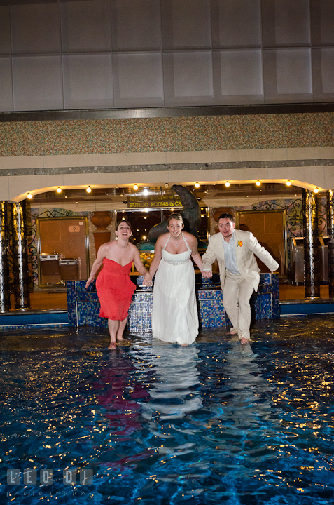 Bride, Groom and Maid of Honor getting ready to jump into swimming pool to trash the dress. Carnival Cruise ship destination wedding reception photos, Cozumel Mexico by photographers of Leo Dj Photography.