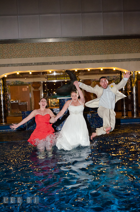 Bride, Groom and Maid of Honor jumping into the swimming pool to trash the dress. Carnival Cruise ship destination wedding reception photos, Cozumel Mexico by photographers of Leo Dj Photography.