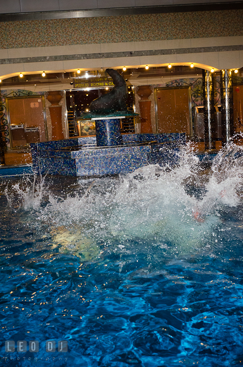 Water splashed after Bride, Groom and Maid of Honor jumped into the swimming pool to trash the dress. Carnival Cruise ship destination wedding reception photos, Cozumel Mexico by photographers of Leo Dj Photography.