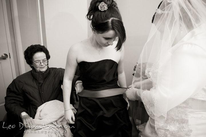 Bride helping bridesmaid put ribbon. Prospect Bay Country Club Grasonville MD Wedding Photographer by Leo Dj Photography