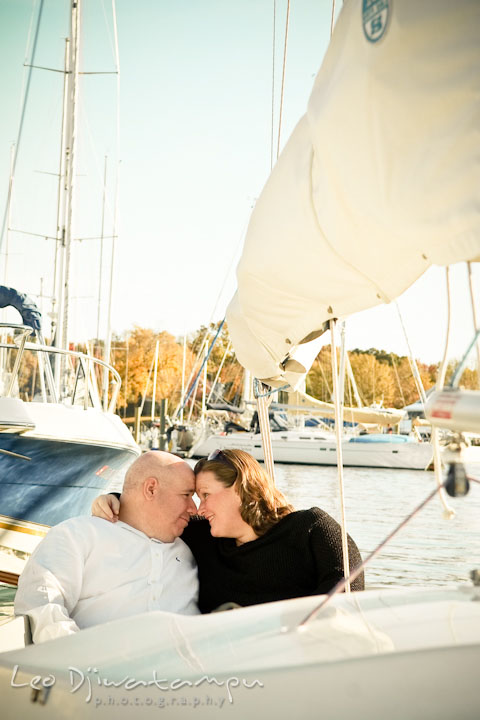 Fiancé and her fiancée cuddling in a sailboat. Annapolis Downtown USNA Pre-wedding Engagement Photographer, Leo Dj Photography