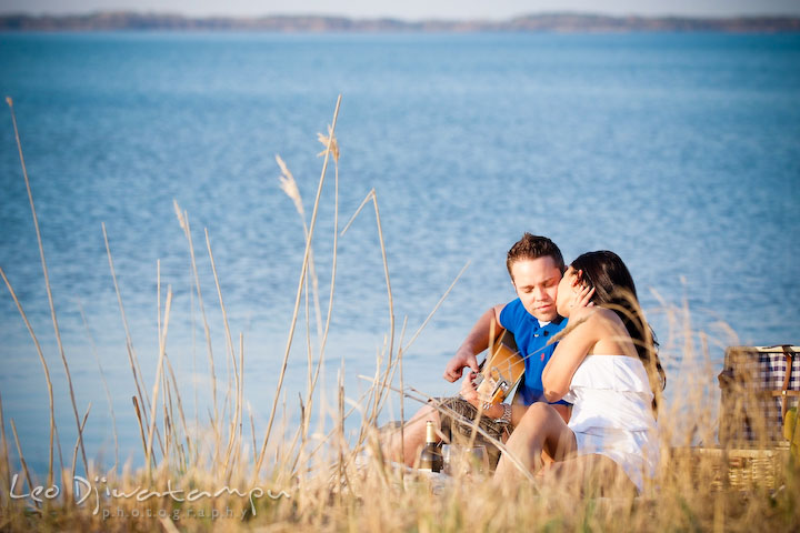 girl kissed guy, blue water on the background. Romantic engagement session on beach Kent Island Maryland