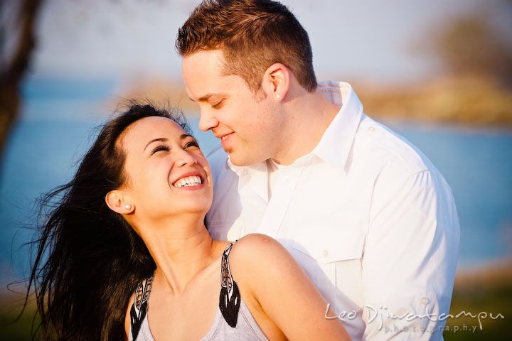 engaged couple looking at each other, laughing. Romantic engagement session on beach Kent Island Maryland