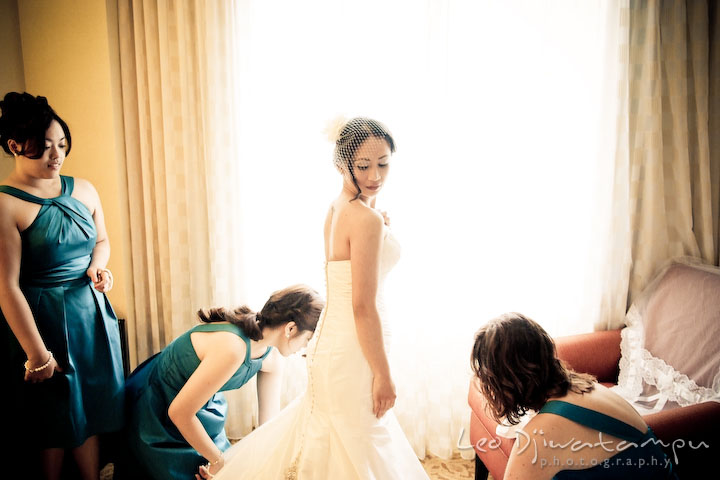 Maid of honor and bridesmaids helps bride arranging her wedding dress. Falls Church Virginia 2941 Restaurant Wedding Photography
