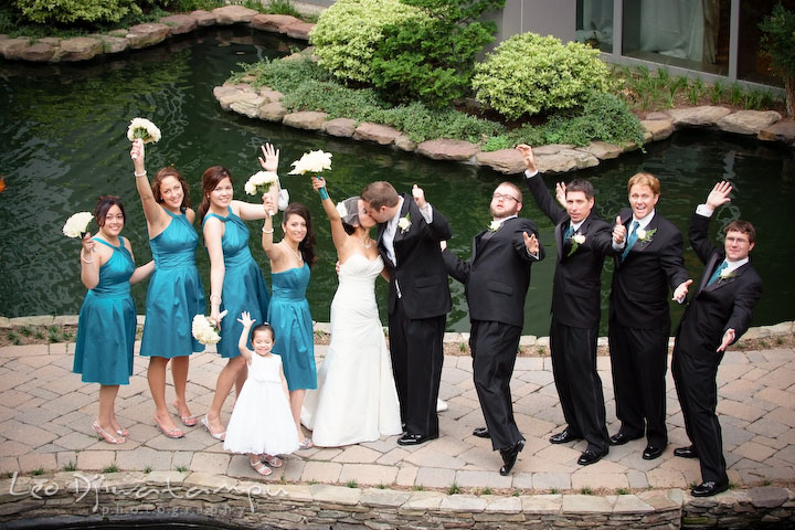The whole bridal party shouting with joy raising hands as the bride and groom kissed. Falls Church Virginia 2941 Restaurant Wedding Photography