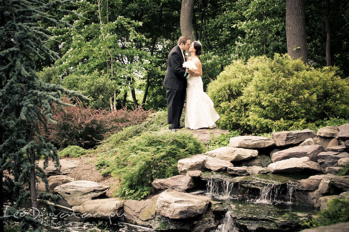 Bride and groom kissing by a waterfall. Falls Church Virginia 2941 Restaurant Wedding Photography