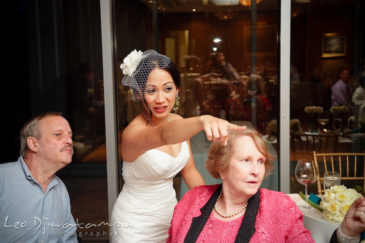 Bride pointing at someone, showing groom's grandmother. Falls Church Virginia 2941 Restaurant Wedding Photographer