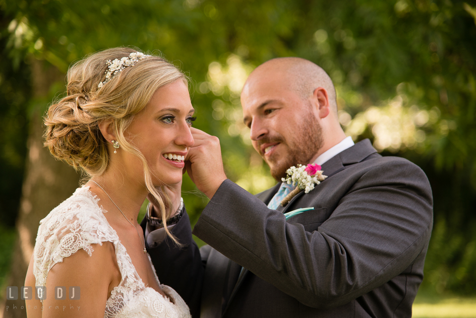 The Oaks Waterfront Inn Groom put on earrings on Bride's ears photo by Leo Dj Photography