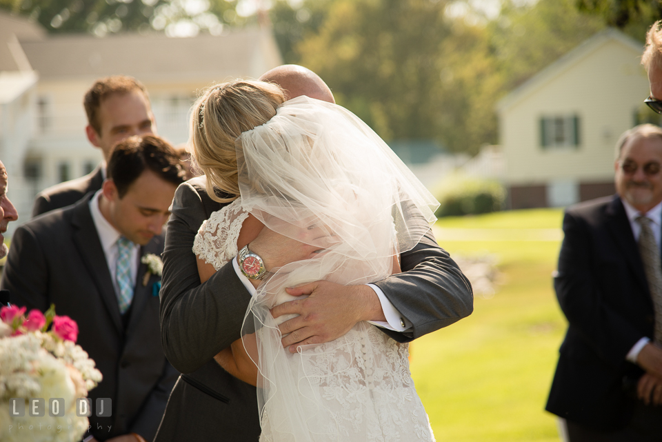 The Oaks Waterfront Inn Groom hugging Bride after Father gave away daughter photo by Leo Dj Photography