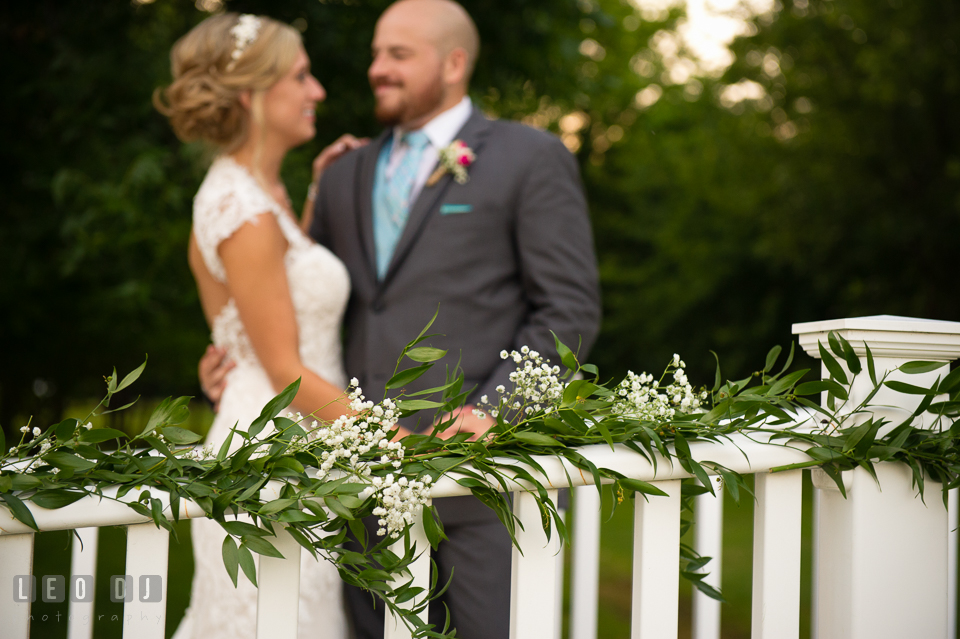 The Oaks Waterfront Inn Bride and Groom on bridge with flowers by florist Seasonal Flowers photo by Leo Dj Photography