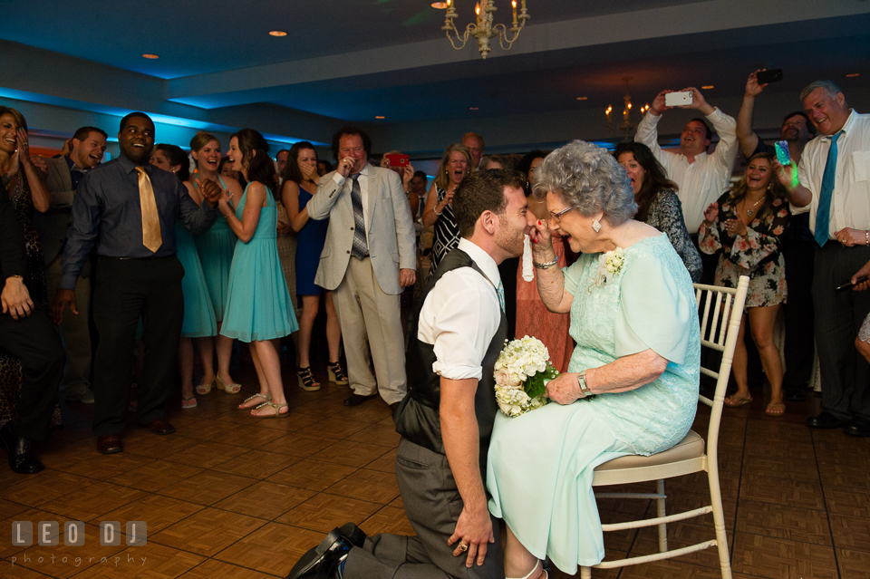 The Oaks Waterfront Inn Grandmother pinched nose of Groomsman kneeling with garter photo by Leo Dj Photography