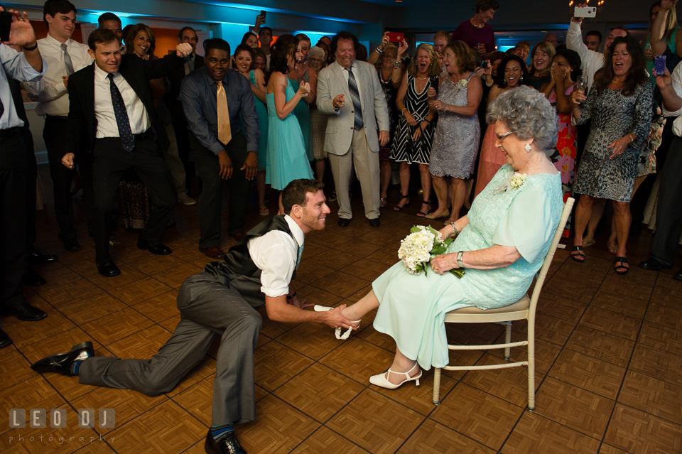 The Oaks Waterfront Inn Groomsman almost laying on floor putting garter on Grandmother's leg by Leo Dj Photography