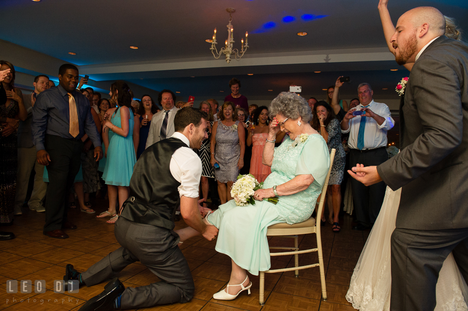 The Oaks Waterfront Inn Groomsman put garter on Grandmother, cheered on by Bride, Groom and all guests photo by Leo Dj Photography