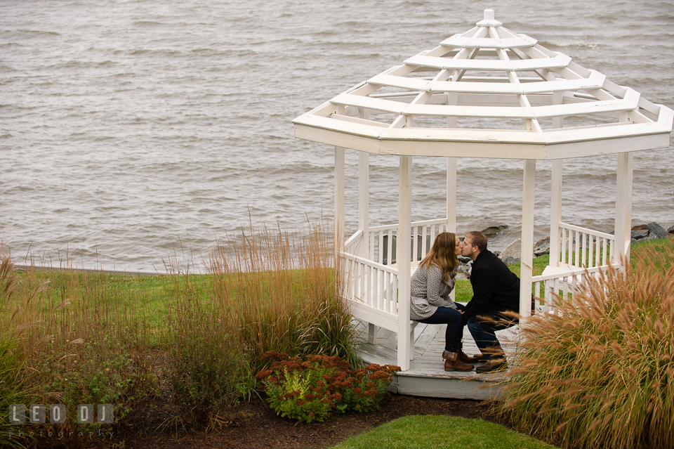 Engaged couple kissing under a gazebo by the water. Eastern Shore Maryland pre-wedding engagement photo session at St Michaels MD, by wedding photographers of Leo Dj Photography. http://leodjphoto.com