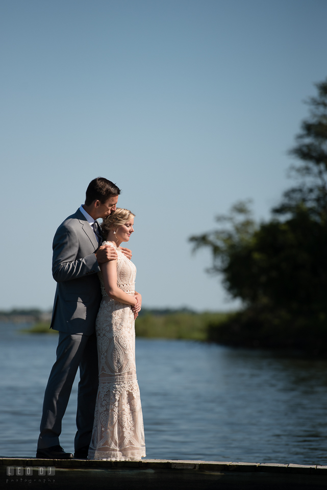 Kent Manor Inn wedding groom embracing bride by the water on the boat pier dock photo by Leo Dj Photography