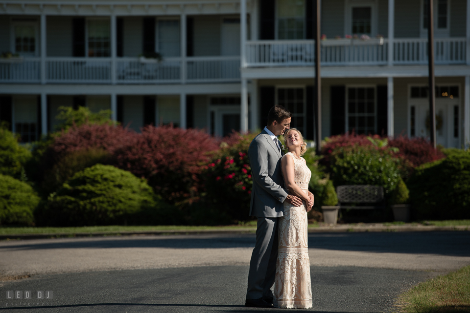 Kent Manor Inn wedding groom and bride cuddling by front garden photo by Leo Dj Photography