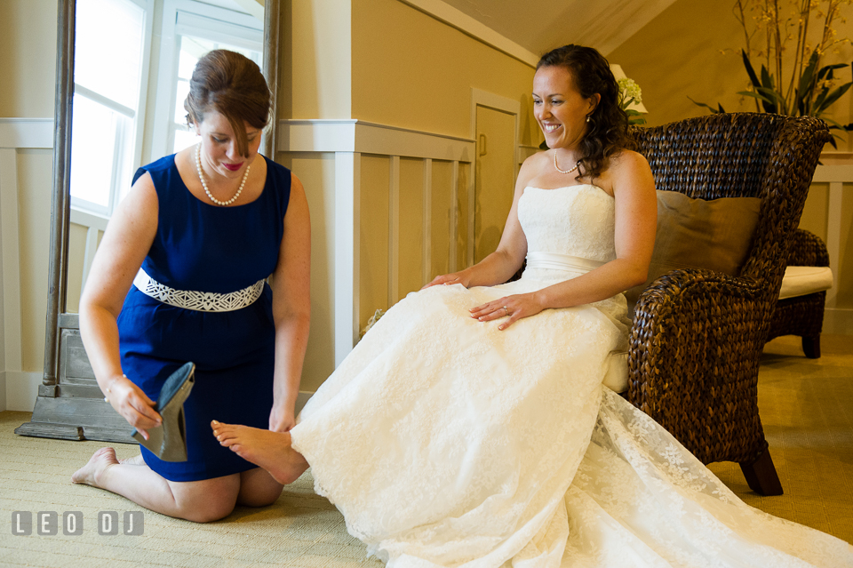 Maid of Honor help Bride put on her shoes. Kent Island Maryland Chesapeake Bay Beach Club wedding photo, by wedding photographers of Leo Dj Photography. http://leodjphoto.com