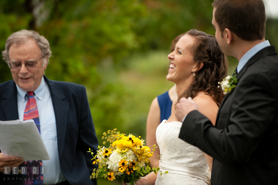 Bride and Groom laughing during the wedding ceremony listening to Uncle's speech. Kent Island Maryland Chesapeake Bay Beach Club wedding photo, by wedding photographers of Leo Dj Photography. http://leodjphoto.com