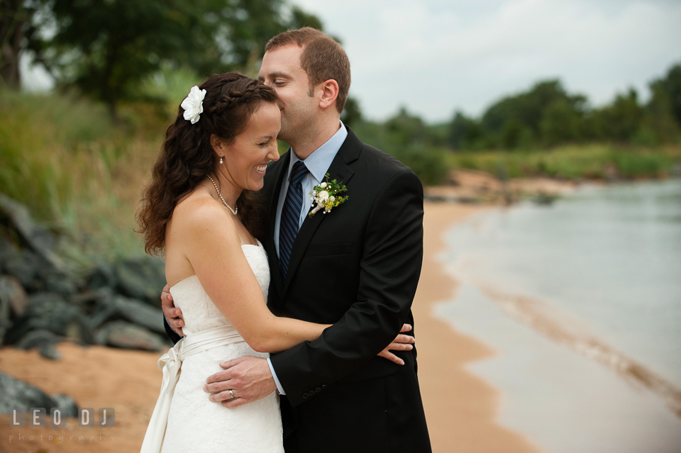 Groom kissing Bride by the beach. Kent Island Maryland Chesapeake Bay Beach Club wedding photo, by wedding photographers of Leo Dj Photography. http://leodjphoto.com