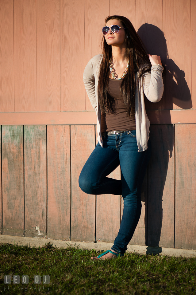 Brunette girl with sun glasses leaning on a wall. Eastern Shore, Maryland, Queen Anne's County High School senior portrait session by photographer Leo Dj Photography. http://leodjphoto.com