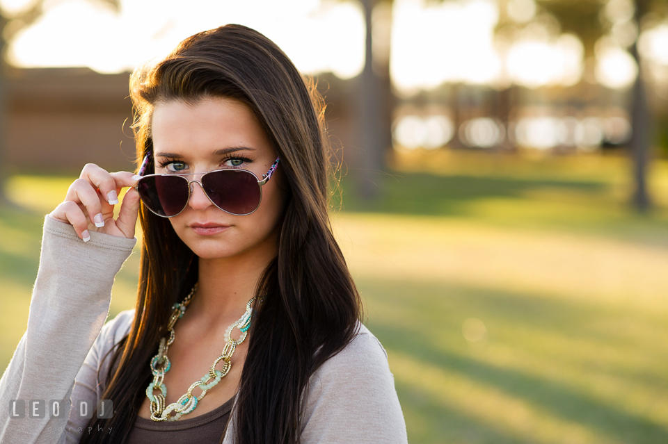 Beautiful brunette girl with beautiful eyes peeking through her sunglasses. Eastern Shore, Maryland, Queen Anne's County High School senior portrait session by photographer Leo Dj Photography. http://leodjphoto.com