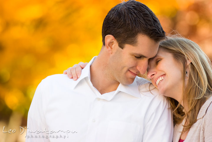 Happy engaged couple cuddling. Pre-wedding engagement photo session at Washington College and Chestertown, Maryland, by wedding photographer Leo Dj Photography.