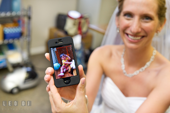 Bride showed picture on iPhone. St Andrews United Methodist wedding photos at Annapolis, Eastern Shore, Maryland by photographers of Leo Dj Photography.