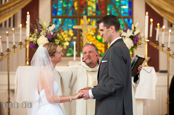 Bride and Groom smiled while blessed by the priest. St Andrews United Methodist wedding photos at Annapolis, Eastern Shore, Maryland by photographers of Leo Dj Photography.