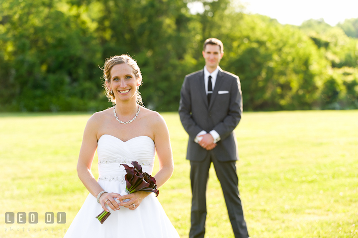 Bride posing in front of Groom in the background. St Andrews United Methodist wedding photos at Annapolis, Eastern Shore, Maryland by photographers of Leo Dj Photography.