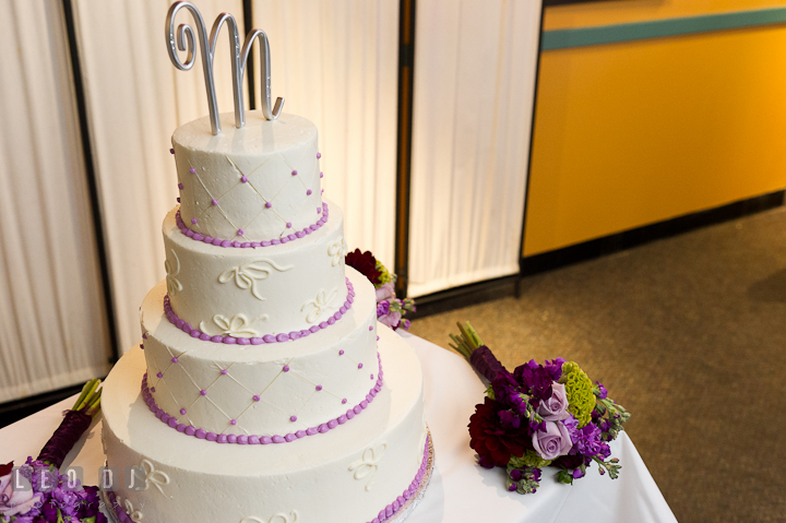Wedding cake with a metal initial letter as a topper from Cake and Confections. Yellowfin Restaurant wedding reception photos at Annapolis, Eastern Shore, Maryland by photographers of Leo Dj Photography.