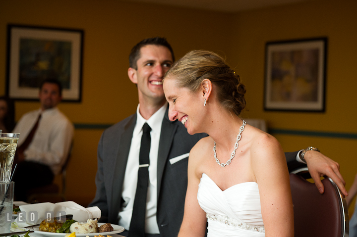 Bride and Groom laughing hearing the speech from Matron of Honor and Best Man. Yellowfin Restaurant wedding reception photos at Annapolis, Eastern Shore, Maryland by photographers of Leo Dj Photography.