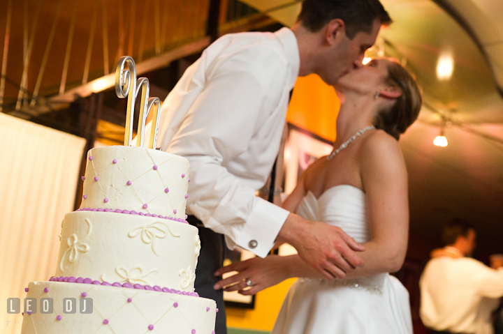 Bride and Groom kissing after the cake cutting. Yellowfin Restaurant wedding reception photos at Annapolis, Eastern Shore, Maryland by photographers of Leo Dj Photography.
