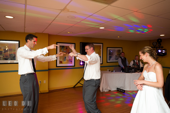 Groom dancing with brother, best man. Bride laughing. Yellowfin Restaurant wedding reception photos at Annapolis, Eastern Shore, Maryland by photographers of Leo Dj Photography.
