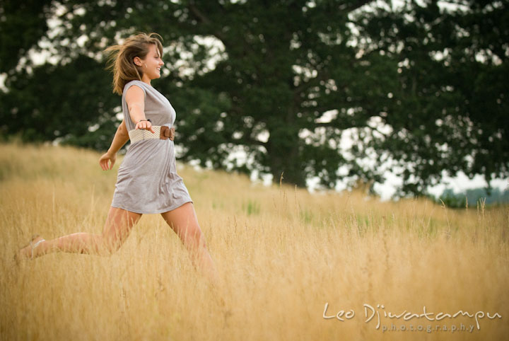 Girl running and jumping in the tall grass field. Eastern Shore, Maryland, Kent Island High School senior portrait session by photographer Leo Dj Photography.