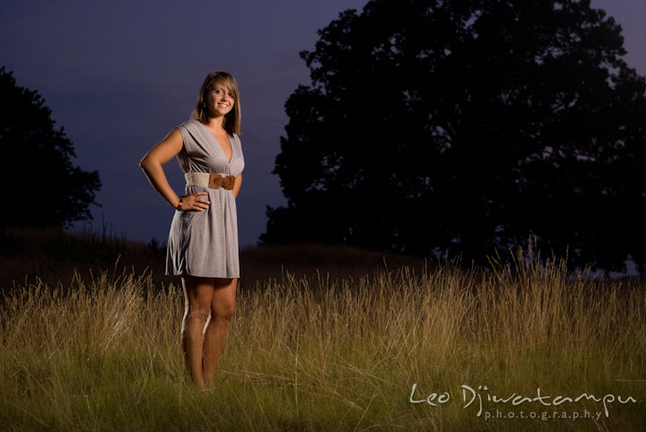 Girl posing in a grass field with evening sky. Eastern Shore, Maryland, Kent Island High School senior portrait session by photographer Leo Dj Photography.