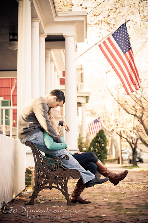 Engaged couple sitting on a bench. Fiancé kissed his fiancée's forehead. Chestertown Maryland and Washington College Pre-Wedding Engagement Session Photographer, Leo Dj Photography