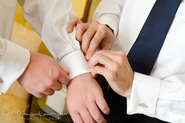 Best man and groom putting on Ravens football team cuff links. The Tidewater Inn Wedding, Easton Maryland, getting ready photo coverage of Kelsey and Jonnie by wedding photographers of Leo Dj Photography.