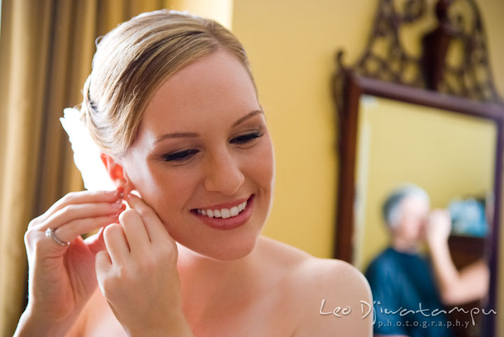 Bride putting on her earrings. The Tidewater Inn Wedding, Easton Maryland, getting ready photo coverage of Kelsey and Jonnie by wedding photographers of Leo Dj Photography.