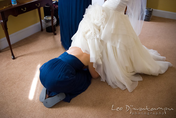 Maid of honor snuck under bride's dress to put shoes. The Tidewater Inn Wedding, Easton Maryland, getting ready photo coverage of Kelsey and Jonnie by wedding photographers of Leo Dj Photography.